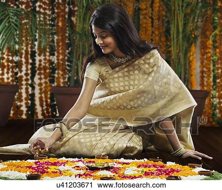 Stock Image - Woman lighting diyas . Fotosearch