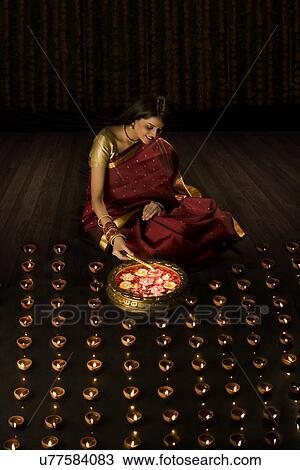 Woman lighting diyas View Large Photo Image Stock Image - Woman lighting diyas . Fotosearch