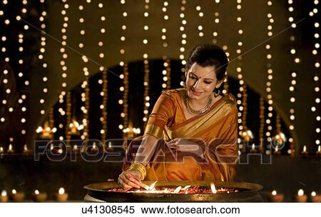 Woman lighting diyas View Large Photo Image Stock Photography - Woman lighting diyas . Fotosearch