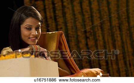 Woman looking at diyas View Large Photo Image Stock Photograph - Woman looking at diyas . Fotosearch
