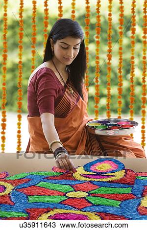 Stock Image - Woman making a rangoli . Fotosearch
