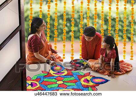 Woman making a rangoli while her children watch View Large Photo Image Stock Image - Woman making a rangoli while her children watch . Fotosearch