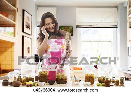 Woman making pickle while talking on the phone View Large Photo Image Picture - Woman making pickle while talking on the phone . Fotosearch