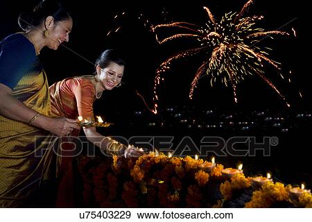 Woman placing diyas on the balcony  View Large Photo Image Stock Photo - Woman placing diyas on the balcony . Fotosearch