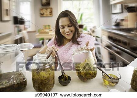 Woman putting pickle into a bowl View Large Photo Image Stock Photo - Woman putting pickle into a bowl . Fotosearch