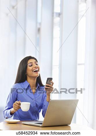 Woman reading an sms on a mobile phone View Large Photo Image Picture - Woman reading an sms on a mobile phone . Fotosearch