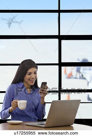 Stock Photography - Woman reading an sms on a mobile phone . Fotosearch