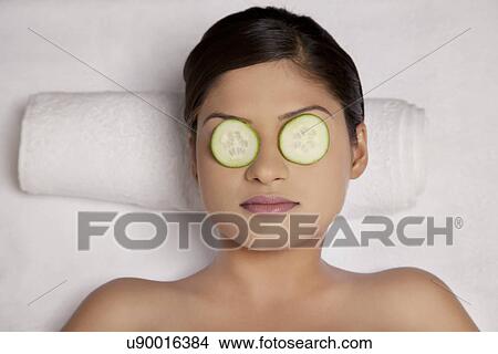 Woman relaxing with cucumber slices on her eyes at spa View Large Photo Image Picture - Woman relaxing with cucumber slices on her eyes at spa . Fotosearch