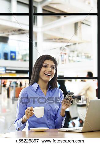Stock Photo - Woman sitting with a cup of coffee . Fotosearch