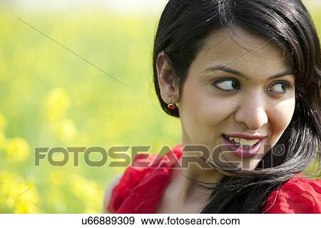 Stock Photo - Woman smiling in a field . Fotosearch