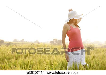 Woman standing in a field View Large Photo Image Picture - Woman standing in a field . Fotosearch