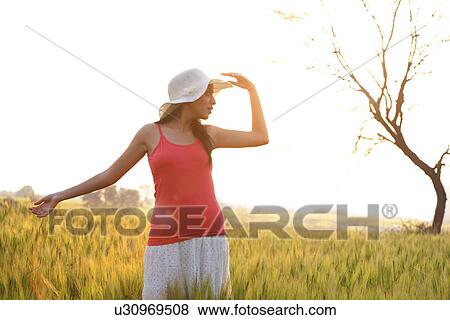 Stock Photo - Woman standing in a field . Fotosearch