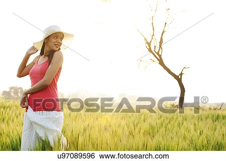 Woman standing in a field View Large Photo Image Stock Photograph - Woman standing in a field . Fotosearch