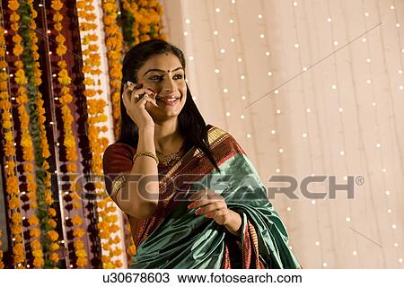 Stock Image - Woman talking on a mobile phone . Fotosearch