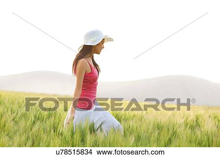 Woman walking through a field View Large Photo Image Picture - Woman walking through a field . Fotosearch