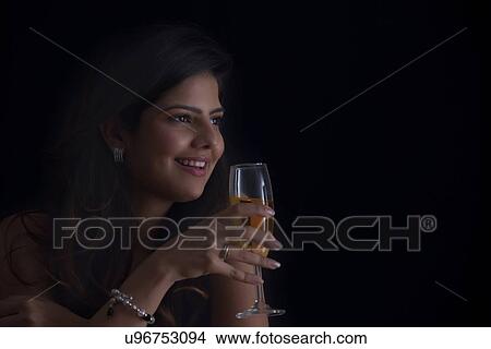 Woman with a glass of wine smiling View Large Photo Image Picture - Woman with a glass of wine smiling. Fotosearch