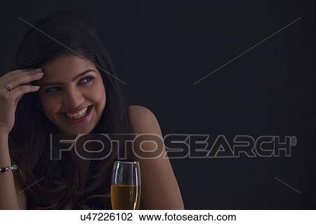 Stock Image - Woman with a glass of wine smiling. Fotosearch