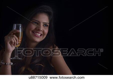Woman with a glass of wine smiling View Large Photo Image Stock Photo - Woman with a glass of wine smiling. Fotosearch