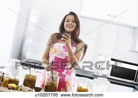 Woman with a mobile phone making pickle View Large Photo Image Stock Photography - Woman with a mobile phone making pickle . Fotosearch