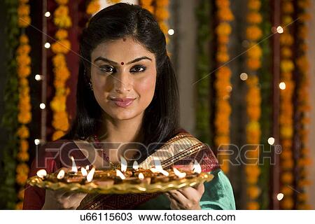 Stock Image - Woman with a tray of diyas . Fotosearch
