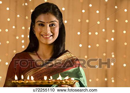 Stock Image - Woman with a tray of diyas . Fotosearch