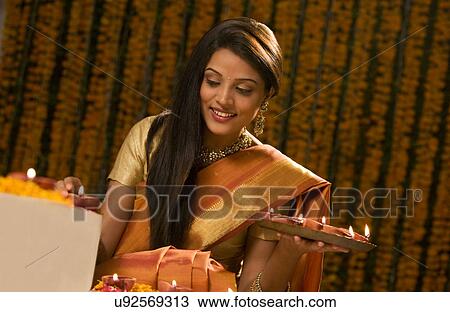 Stock Image - Woman with a tray of diyas . Fotosearch