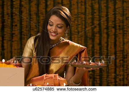 Stock Photography - Woman with a tray of diyas . Fotosearch