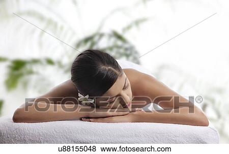 Stock Photo - Woman with eyes closed lying on message table . Fotosearch