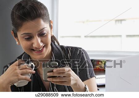 Women reading a message on a mobile phone View Large Photo Image Stock Photo - Women reading a message on a mobile phone . Fotosearch