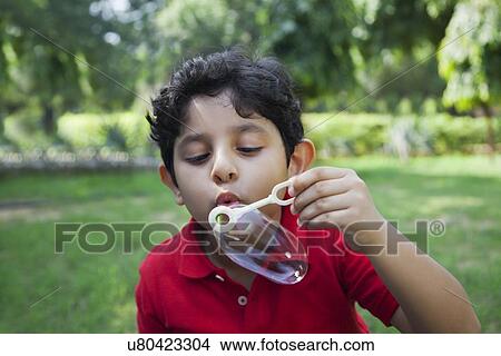 Picture - Young boy blowing bubbles. Fotosearch