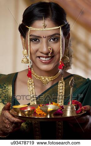 Stock Photo - Young bride with offerings on her wedding day . Fotosearch