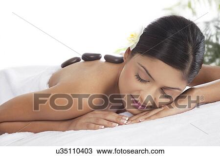 Young female receiving hot stone treatment View Large Photo Image Stock Image - Young female receiving hot stone treatment . Fotosearch