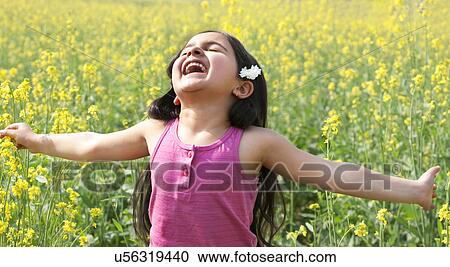 Young girl enjoying herself in a field View Large Photo Image Stock Image - Young girl enjoying herself in a field . Fotosearch