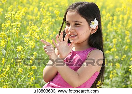 Young girl having fun in a field View Large Photo Image Stock Image - Young girl having fun in a field . Fotosearch