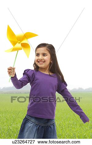 Young girl holding a toy windmill View Large Photo Image Stock Photo - Young girl holding a toy windmill . Fotosearch