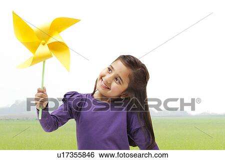 Young girl holding a toy windmill View Large Photo Image Stock Photograph - Young girl holding a toy windmill . Fotosearch