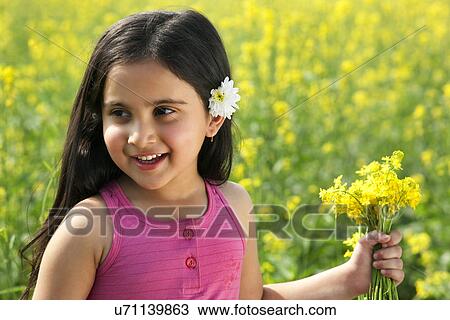 Young girl holding flowers View Large Photo Image Stock Image - Young girl holding flowers . Fotosearch