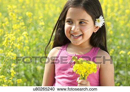 Young girl holding flowers View Large Photo Image Stock Image - Young girl holding flowers . Fotosearch