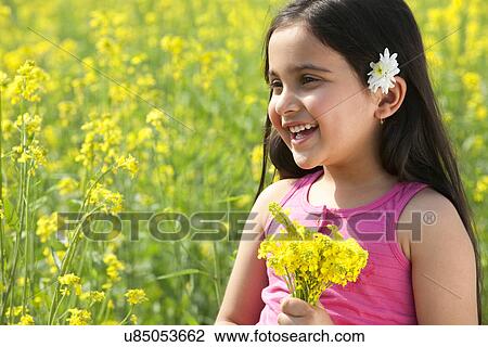 Stock Image - Young girl holding flowers . Fotosearch