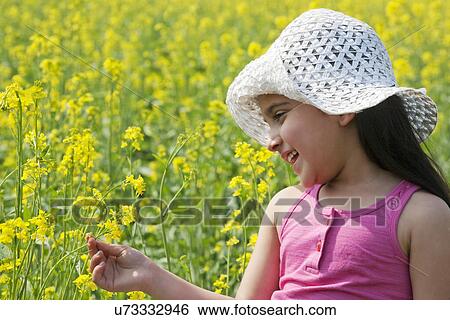 Young girl looking at flowers View Large Photo Image Stock Photograph - Young girl looking at flowers . Fotosearch