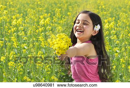 Stock Image - Young girl offering flowers . Fotosearch