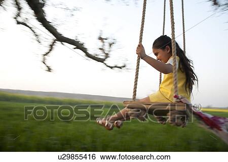 Stock Photograph - Young girl on a swing . Fotosearch