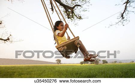 Young girl on a swing View Large Photo Image Stock Photograph - Young girl on a swing . Fotosearch