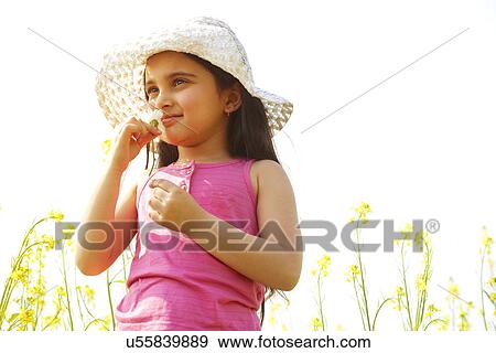 Stock Photo - Young girl smelling a flower . Fotosearch