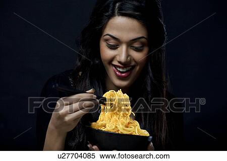 Stock Photography - Young girl with a bowl of noodles . Fotosearch
