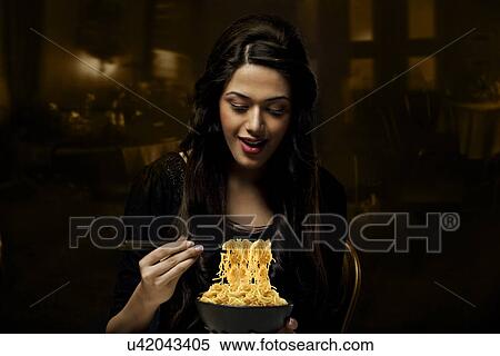 Stock Photography - Young girl with a bowl of noodles . Fotosearch