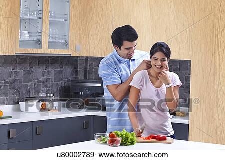 Young man fastening necklace on woman in kitchen View Large Photo Image Stock Photo - Young man fastening necklace on woman in kitchen. Fotosearch