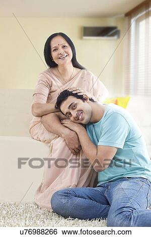 Young man relaxing on mother's lap View Large Photo Image Stock Photograph - Young man relaxing on mother's lap . Fotosearch