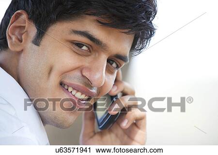 Stock Image - Young man talking on a mobile phone . Fotosearch