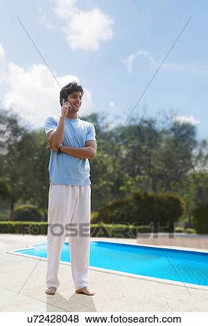 Young man talking on a mobile phone View Large Photo Image Stock Photo - Young man talking on a mobile phone . Fotosearch